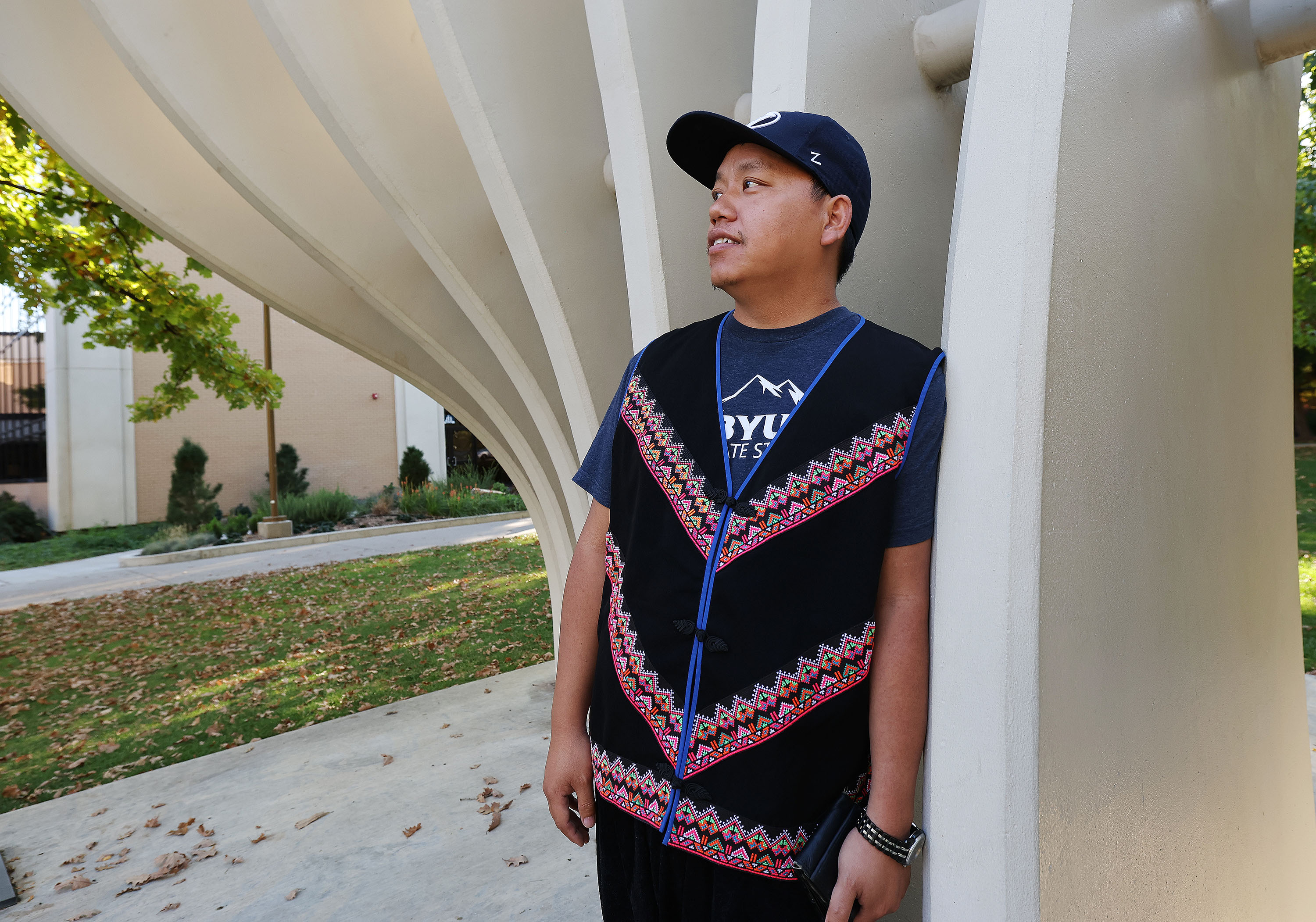 Yang Vang, a Brigham Young University master's degree candidate in anthropology, stands near the Tree of Wisdom sculpture on campus, in Provo on Oct. 13. Vang is also a world-renowned Hmong shaman.