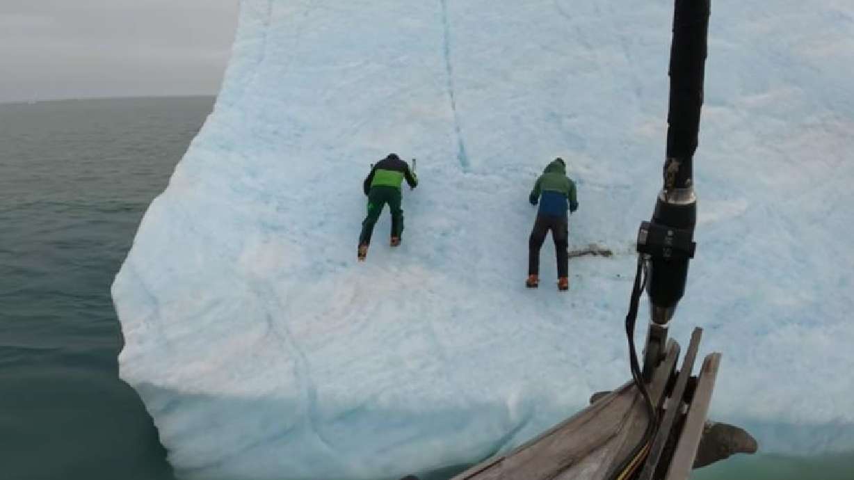 World-class explorers attempt to climb an iceberg in the Arctic Ocean region of Svalbard.