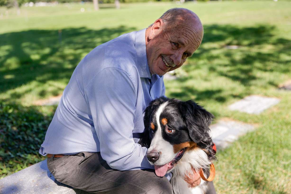 Ron Snarr sits for a portrait with his dog Otto as he looks at his sons' graves at Wasatch Lawn Memorial Park and Mortuary in Millcreek on Sunday, Aug. 28. Snarr’s sons, Levi and Zachary, are buried next to one another.