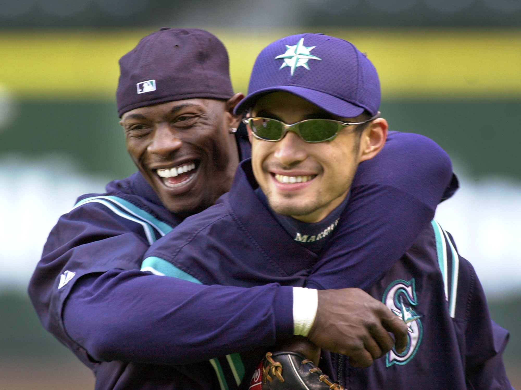 FILE - Seattle Mariners' Mike Cameron, left, embraces teammate Ichiro Suzuki during their workout Monday, Oct. 8, 2001, in Seattle. An entire generation has waited for the Seattle Mariners to bring playoff baseball back to the Pacific Northwest. After a 21-year absence, the postseason is back in Seattle for Game 3 of the ALDS against Houston. 