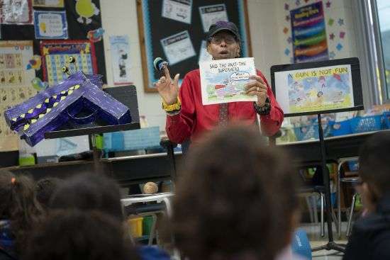 Ian Ellis James, an Emmy award-winning Sesame Street writer known by his stage name William Electric Black, leads a first grade class in a book reading on urban gun violence prevention at the Drexel Avenue School, Oct. 3 in Westbury, New York. Black is the author of the illustrated children’s book “A Gun Is Not Fun.” He said young children in areas afflicted by gun violence are more aware of it than parents may think.