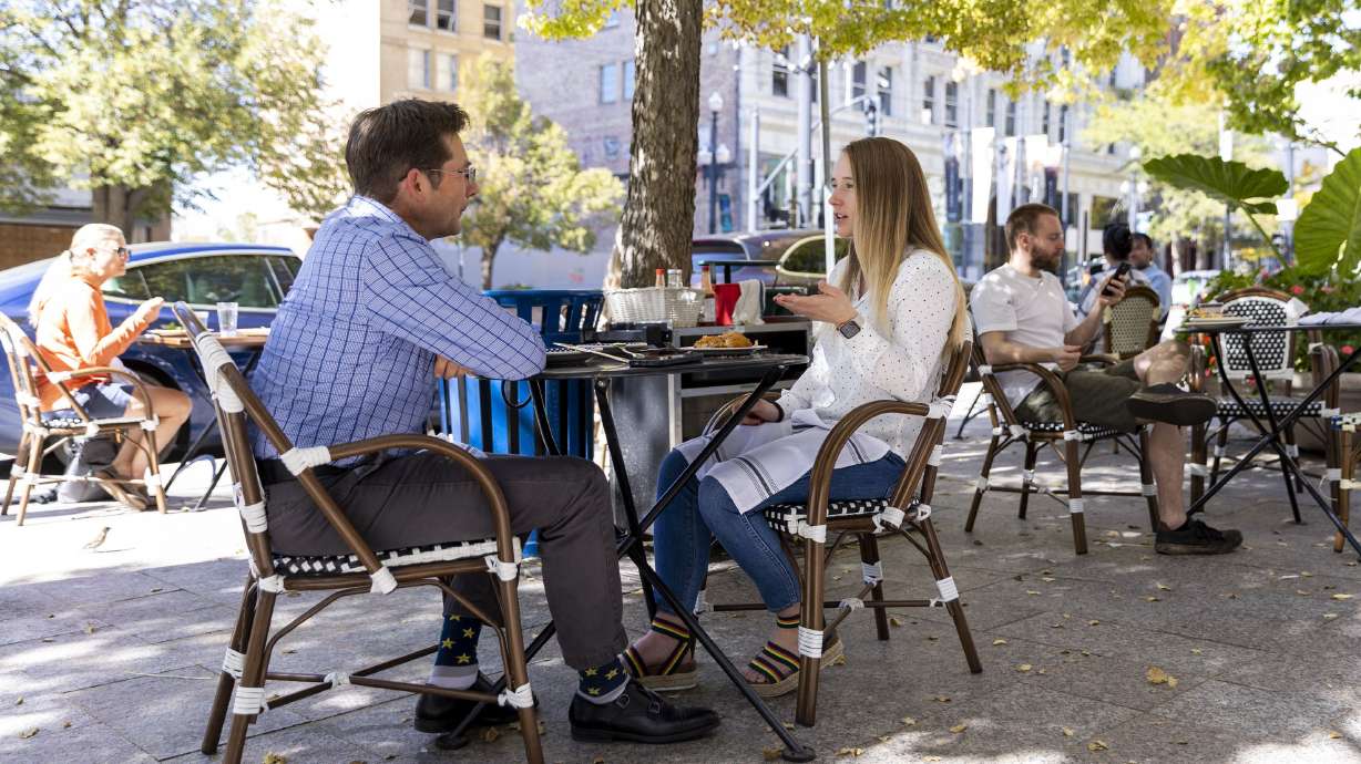 Kevin Jessop and his daughter, Lizzy Gomes, eat and chat outside of Eva’s Bakery in Salt Lake City on Monday. Jessop said “It seems that the pandemic is endemic, so it’s something you have to live with.” Gomes agreed with her father, adding “ditto” afterward.