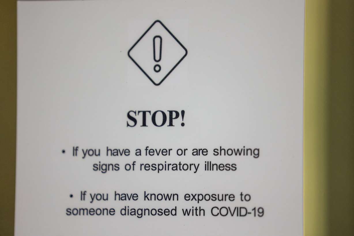 A sign detailing COVID-19 risks is posted on the front of the Clift Building in Salt Lake City on Oct. 10.