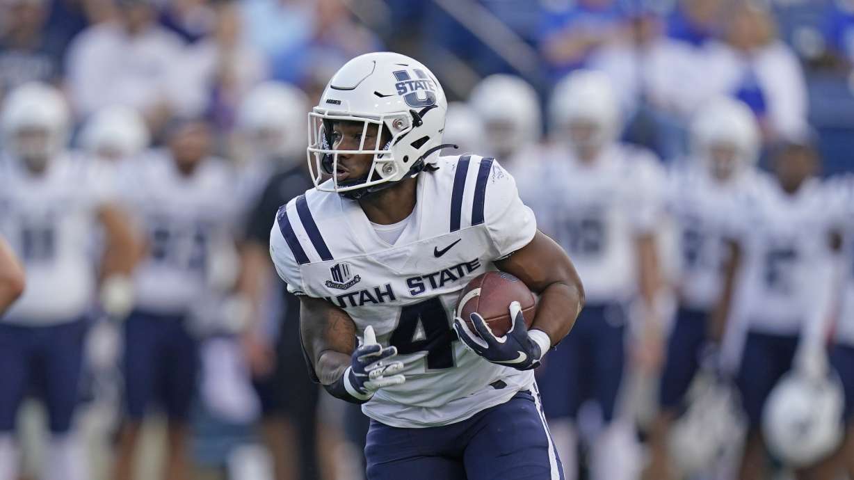 Utah State running back Calvin Tyler Jr. (4) carries the ball against BYU during the first half of an NCAA college football game Thursday, Sept. 29, 2022, in Provo, Utah.