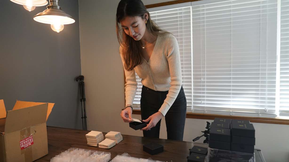 Hannah Nash places jewelry in a box that will be shipped out, Friday in Noblesville, Ind. Nash has her small business at her home. Small businesses are stocking the shelves early this holiday season and waiting to see how many gifts inflation-weary shoppers feel like giving.
