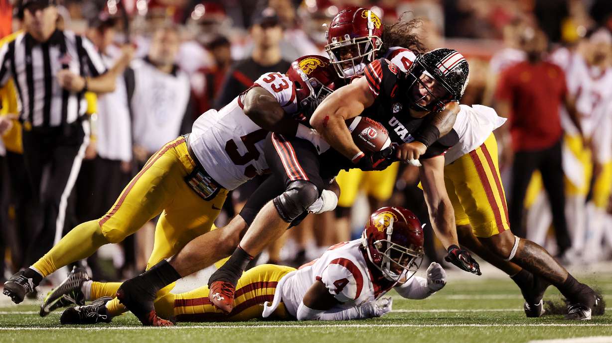 Utah Utes tight end Dalton Kincaid (86) is brought down by USC Trojans linebackers Shane Lee (53) and Tuasivi Nomura (44) as Utah and USC play at Rice Eccles Stadium in Salt Lake City on Saturday, Oct. 15, 2022. Utah won 43-42.