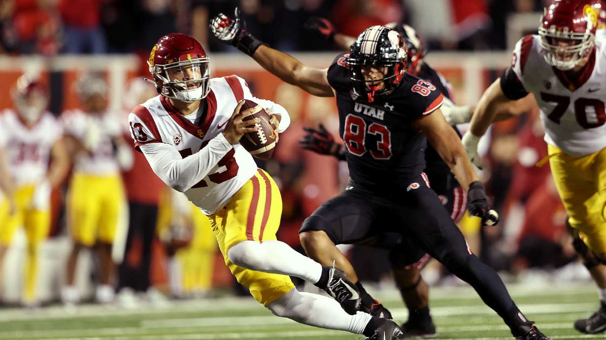 USC Trojans quarterback Caleb Williams (13) spins away from Utah Utes defensive end Jonah Elliss (83) as Utah and USC play at Rice Eccles Stadium in Salt Lake City on Saturday, Oct. 15, 2022. Utah won 43-42.