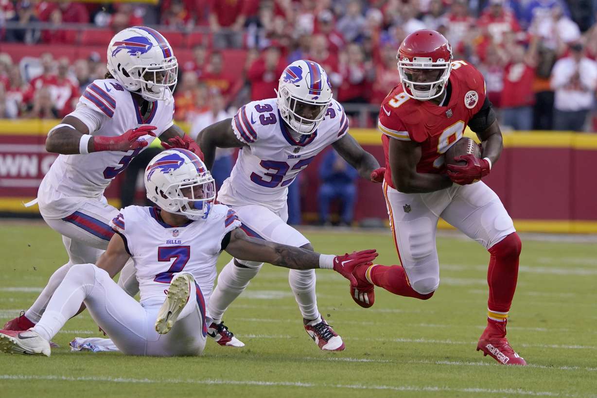 Kansas City Chiefs wide receiver JuJu Smith-Schuster (9) slips past Buffalo Bills safety Damar Hamlin (3), cornerback Taron Johnson (7) and cornerback Siran Neal (33) on his way to a touchdown during the first half of an NFL football game Sunday, Oct. 16, 2022, in Kansas City, Mo.