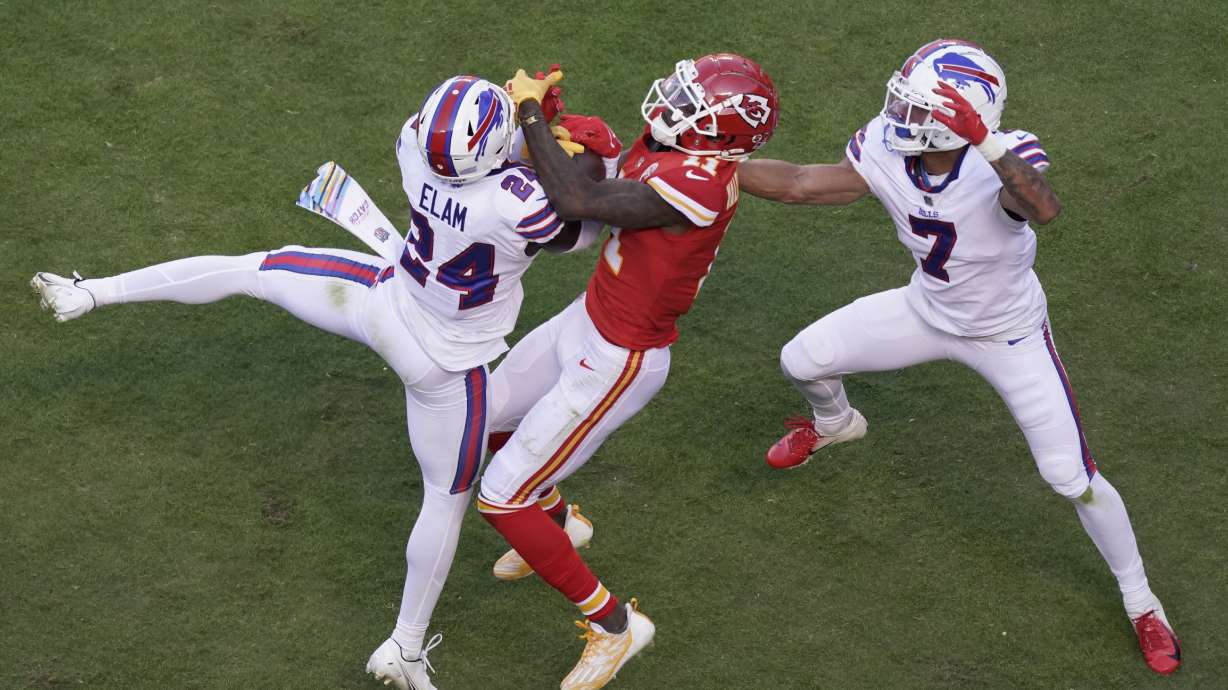 Kansas City Chiefs wide receiver Marquez Valdes-Scantling (11) reaches for a pass as Buffalo Bills cornerback Kaiir Elam (24) and cornerback Taron Johnson (7) defend during the first half of an NFL football game Sunday, Oct. 16, 2022, in Kansas City, Mo.