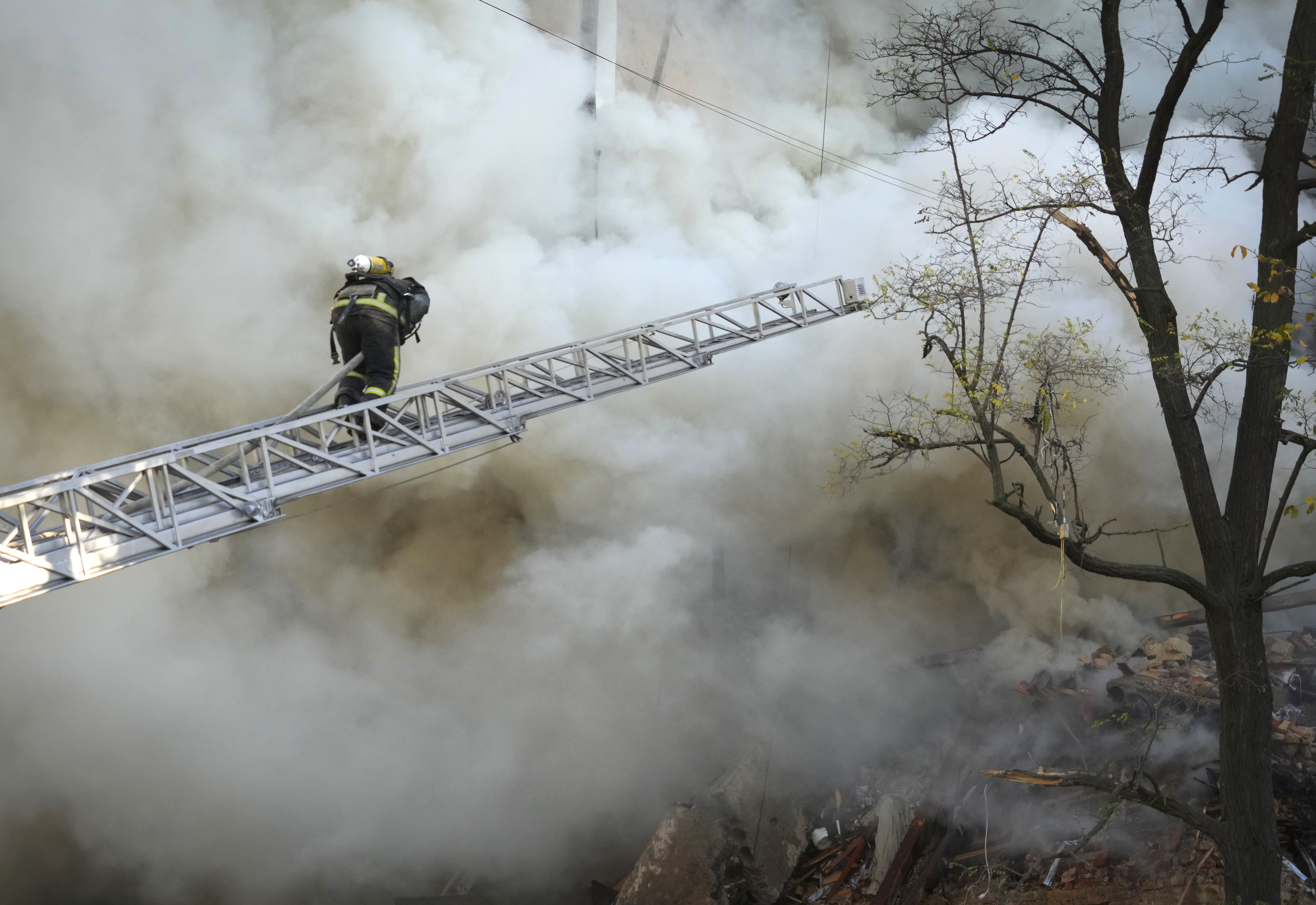 Firefighters work after a drone fired on buildings in Kyiv, Ukraine, Monday.