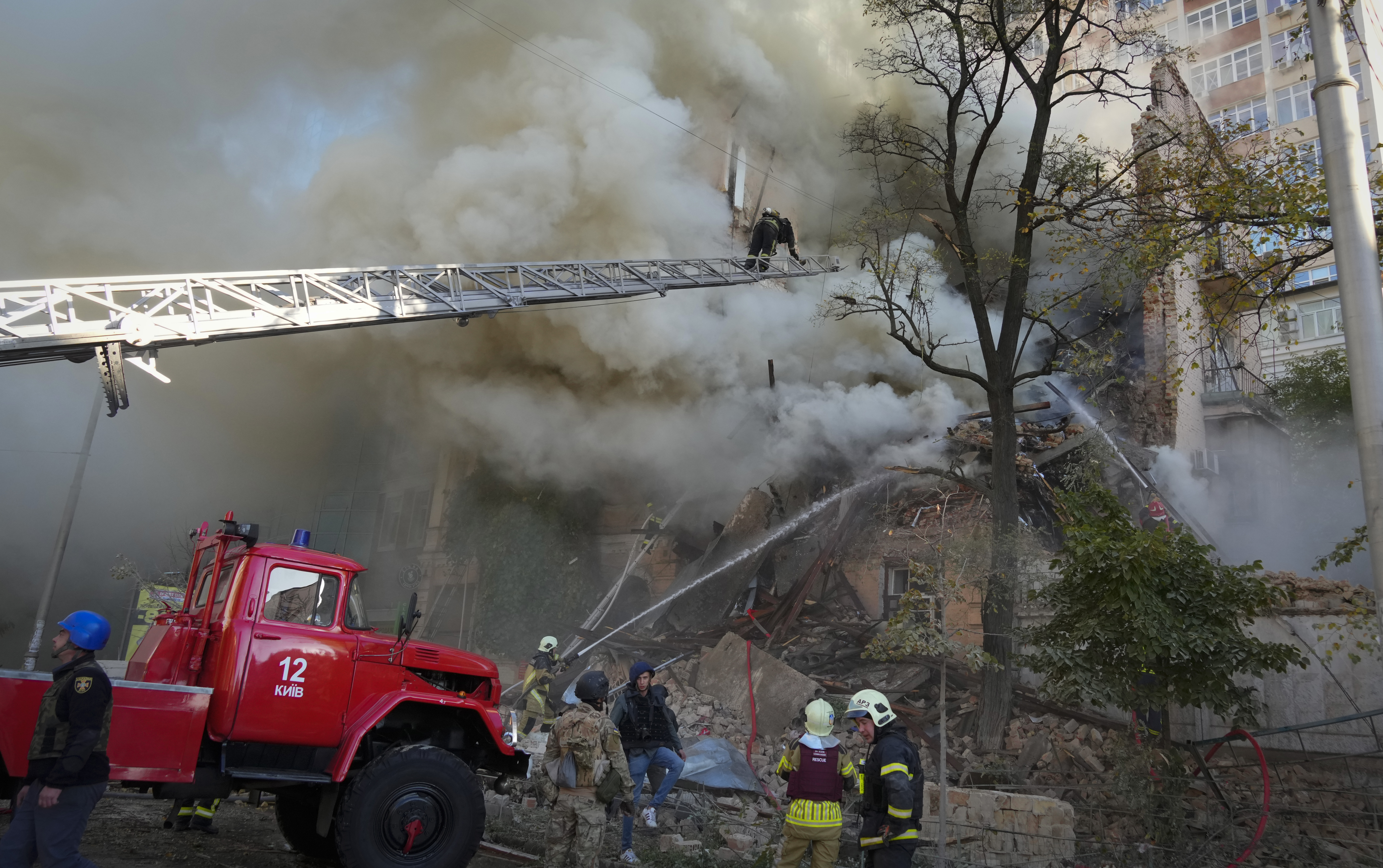 Firefighters work after a drone fired on buildings in Kyiv, Ukraine, Monday.