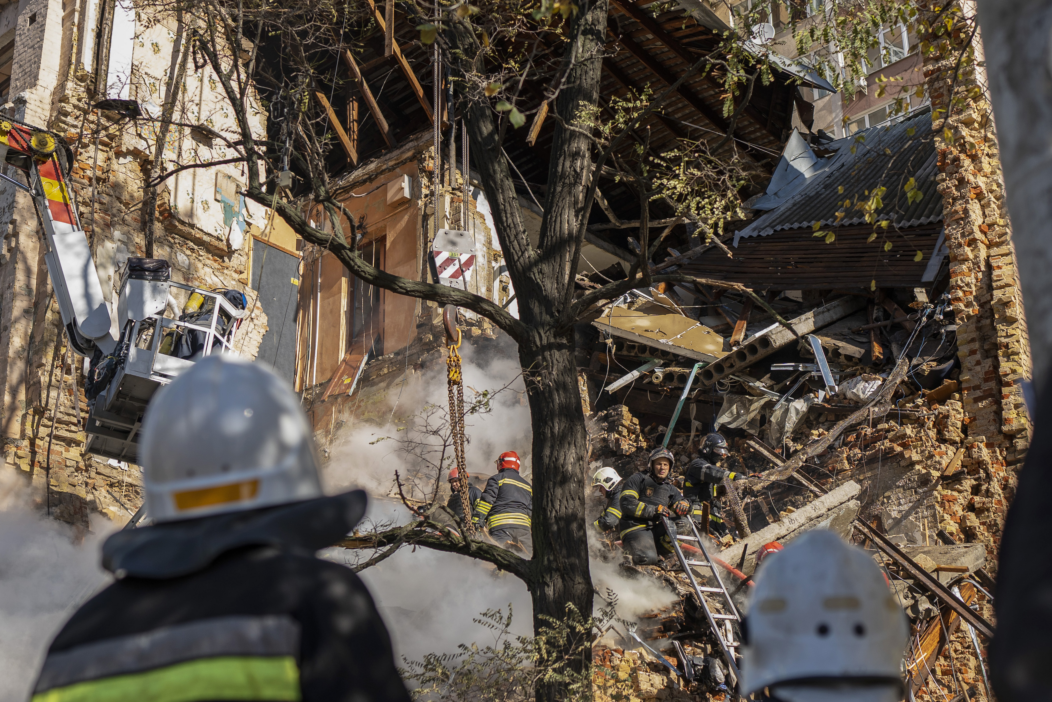 Firefighters work after a drone fired on buildings in Kyiv, Ukraine, Monday. Waves of explosive-laden suicide drones struck Ukraine's capital as families were preparing to start their week early Monday.