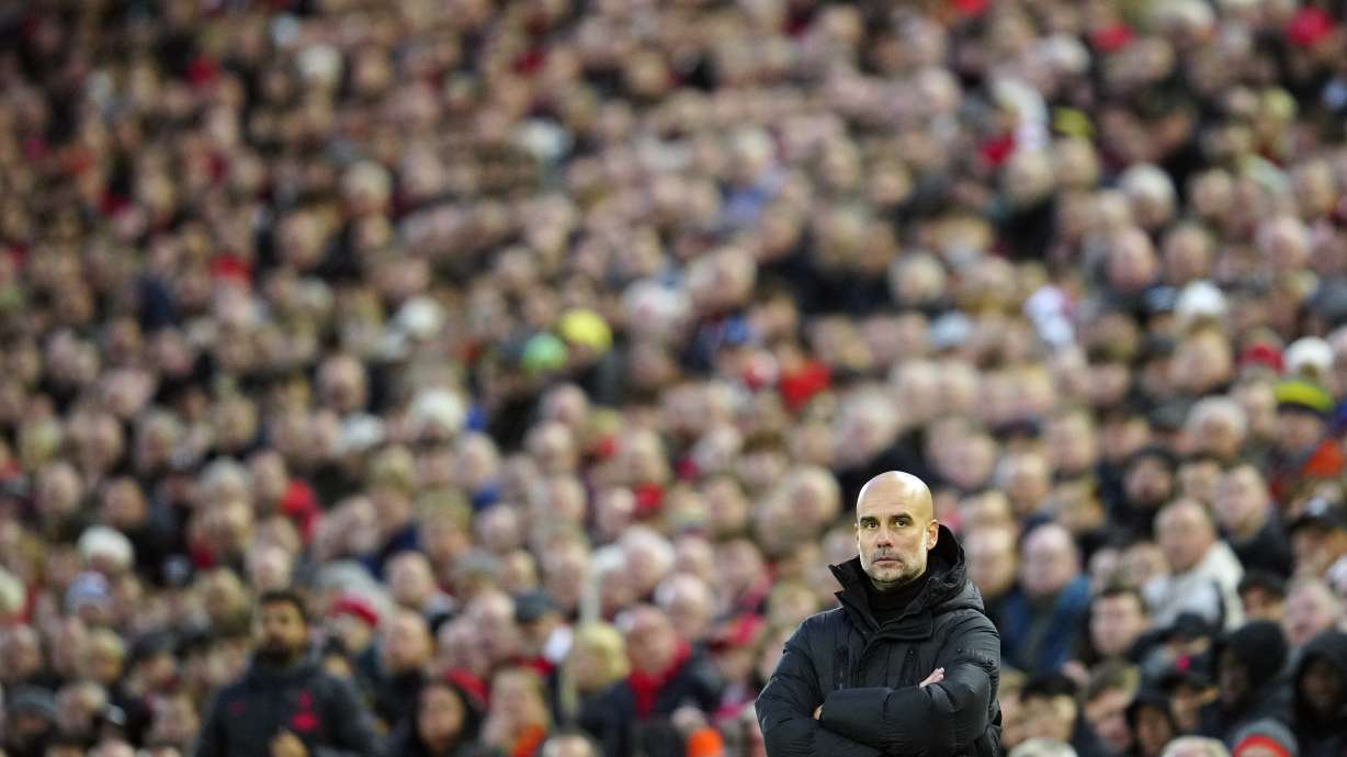 Manchester City's head coach Pep Guardiola looks out during the English Premier League soccer match between Liverpool and Manchester City at Anfield stadium in Liverpool, Sunday, Oct. 16, 2022.