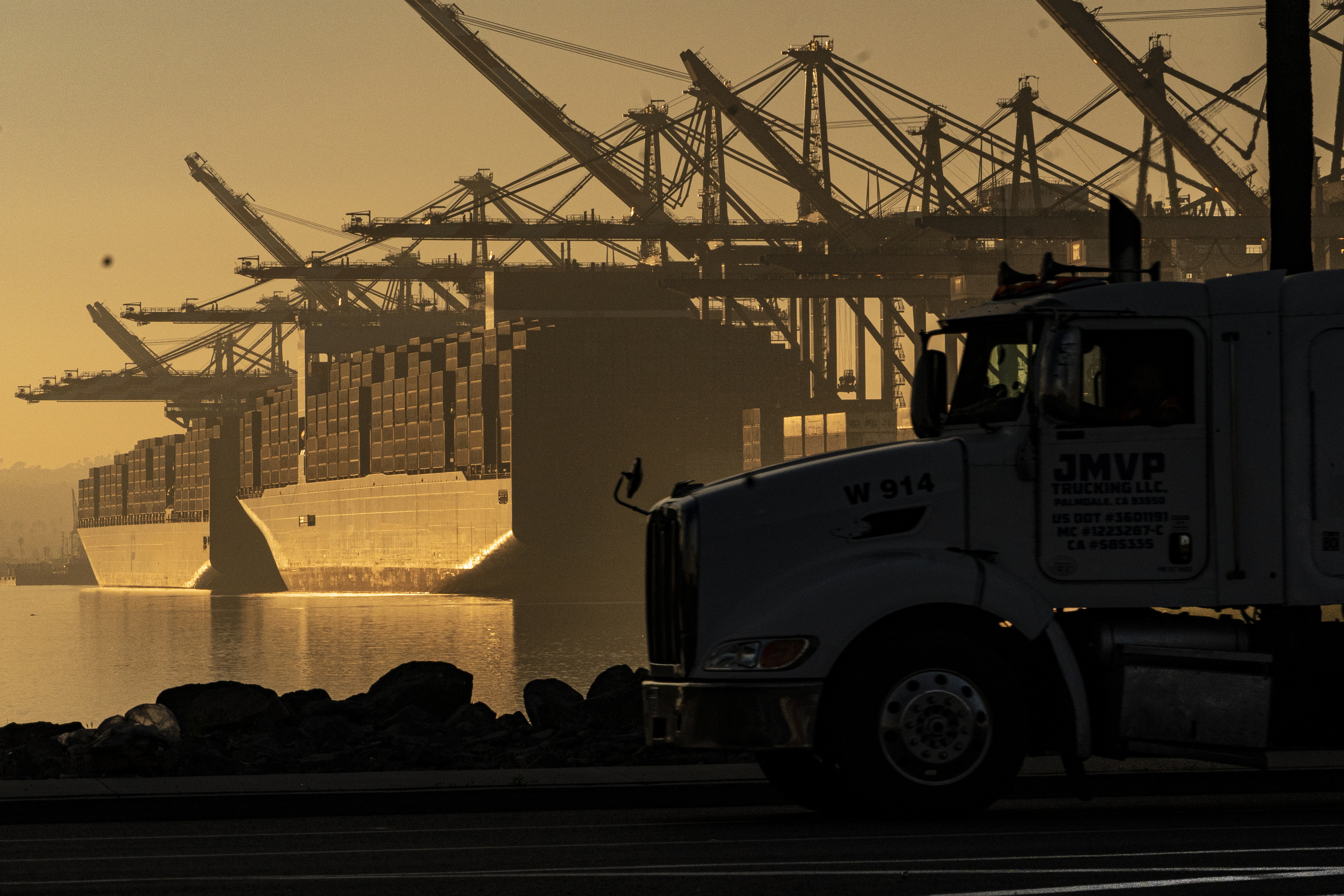 A truck arrives to pick up a shipping container near vessels at the Port of Los Angeles, on Nov. 30, 2021. An influential government advisory panel comprised of major U.S. businesses is proposing new rules that would roll back already limited public access to import data.