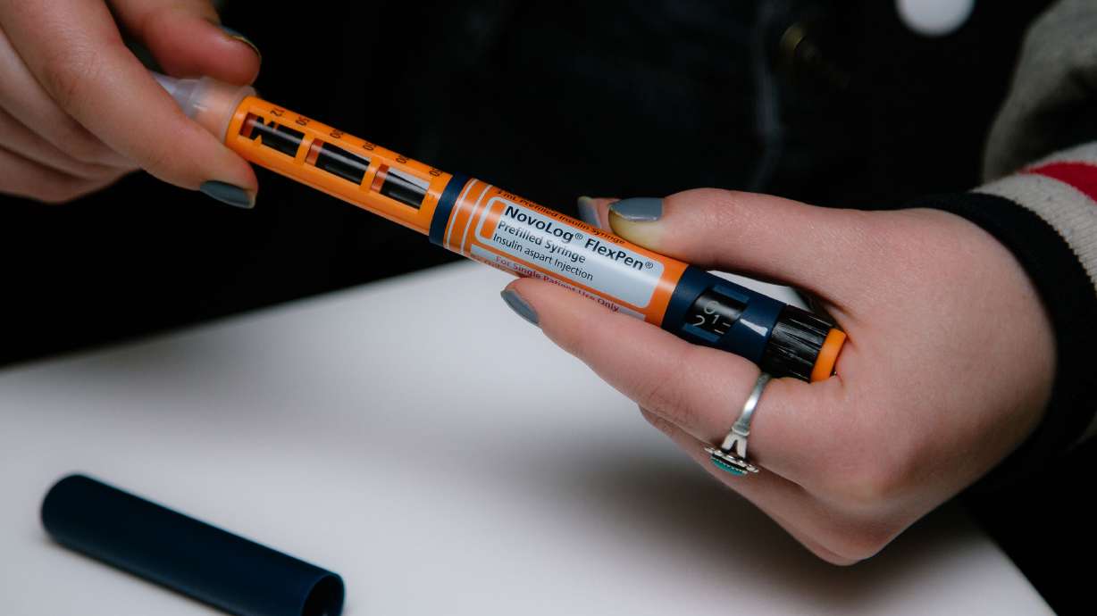 A person fastens a Becton Dickinson And Co. needle on a NovoLog brand insulin pen in New York in April 2019. A new study found that 1.3 million Americans with diabetes rationed insulin in the past year.