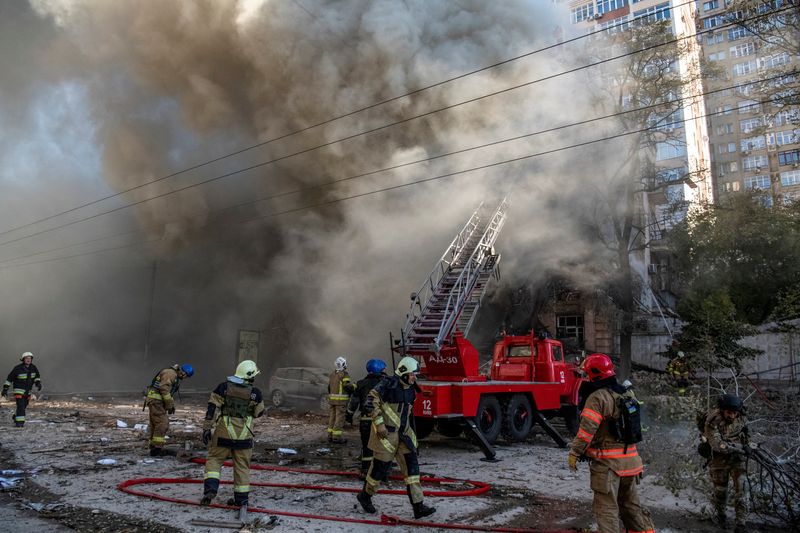 Firefighters help a local woman evacuate from a residential building destroyed by a Russian drone strike amid Russia's attack on Ukraine, in Kyiv, Ukraine Monday. Ukraine said Tuesday Russia had destroyed almost a third of its power stations over the past week.