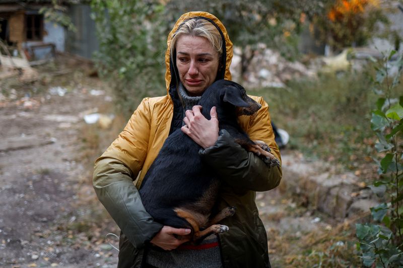 A woman carries a dog at the site of a residential building heavily damaged by a Russian missile strike, amid Russia’s attack on Ukraine, in Mykolaiv, Ukraine, Tuesday.