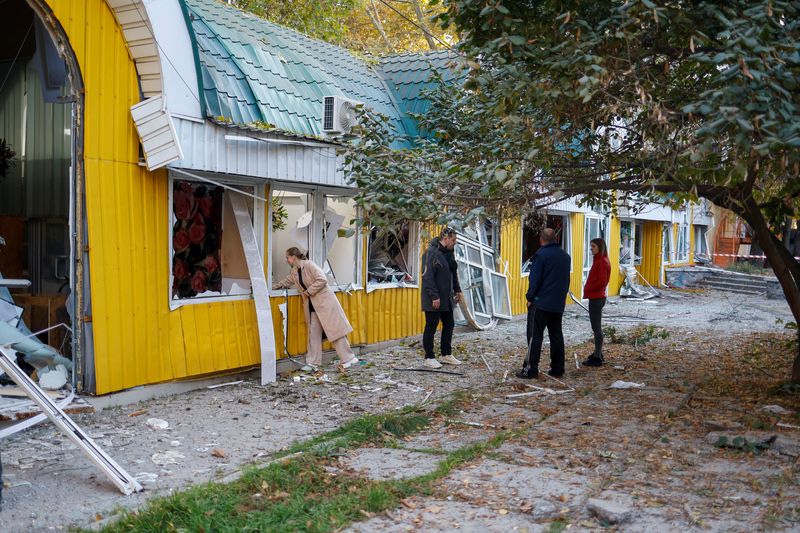 Owners stand next to flower shops damaged by a Russian missile strike in a park, amid Russia’s attack on Ukraine, in Mykolaiv, Ukraine, Tuesday.