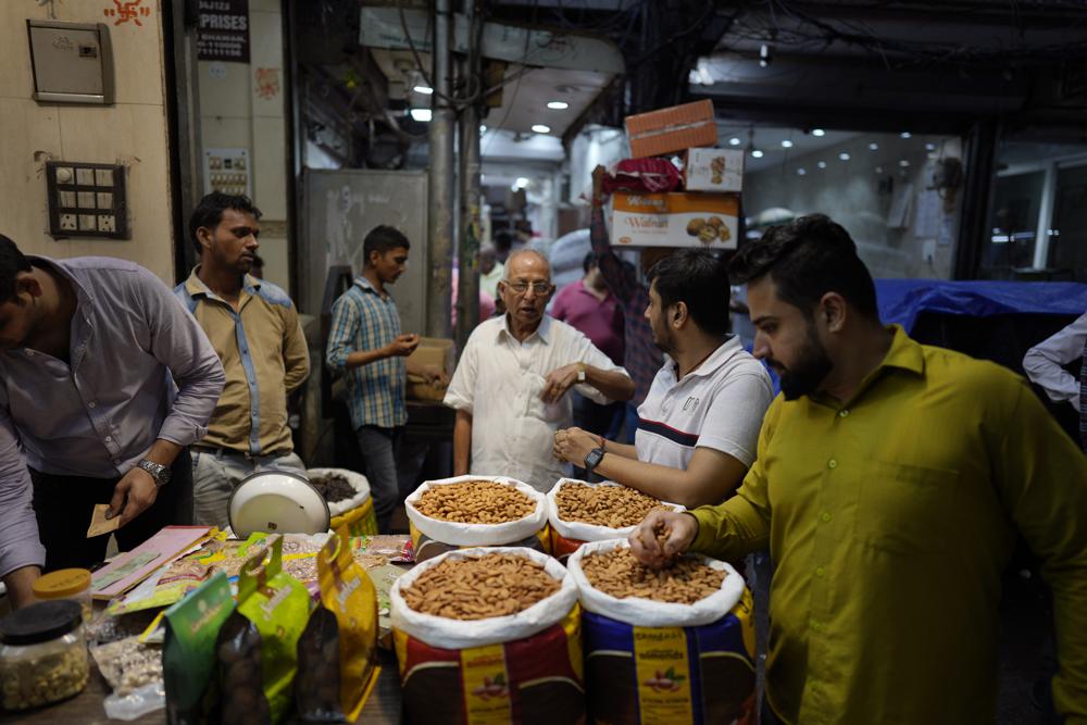 Small retailers shop for dry fruits in a wholesale market, in New Delhi, Monday. A record drop in the rupee — on top of higher raw material and shipping costs — has made the nuts much costlier for Indian consumers. As the value of the U.S. dollar soars, other currencies around the world are sinking by comparison.