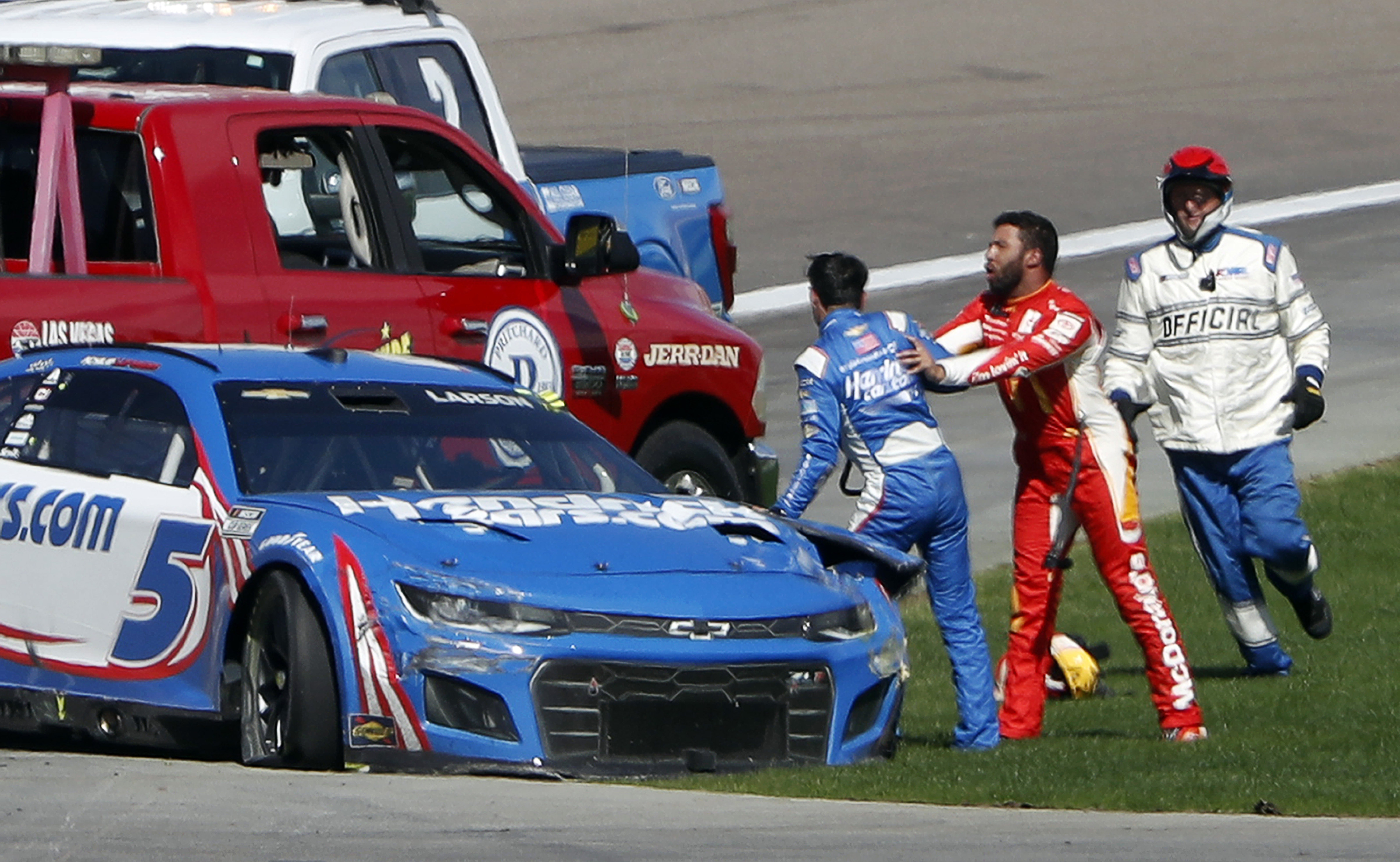 Bubba Wallace, center, shoves Kyle Larson (5), left, after they crashed during a NASCAR Cup Series auto race at Las Vegas Motor Speedway in Las Vegas, Sunday, Oct. 16, 2022. 