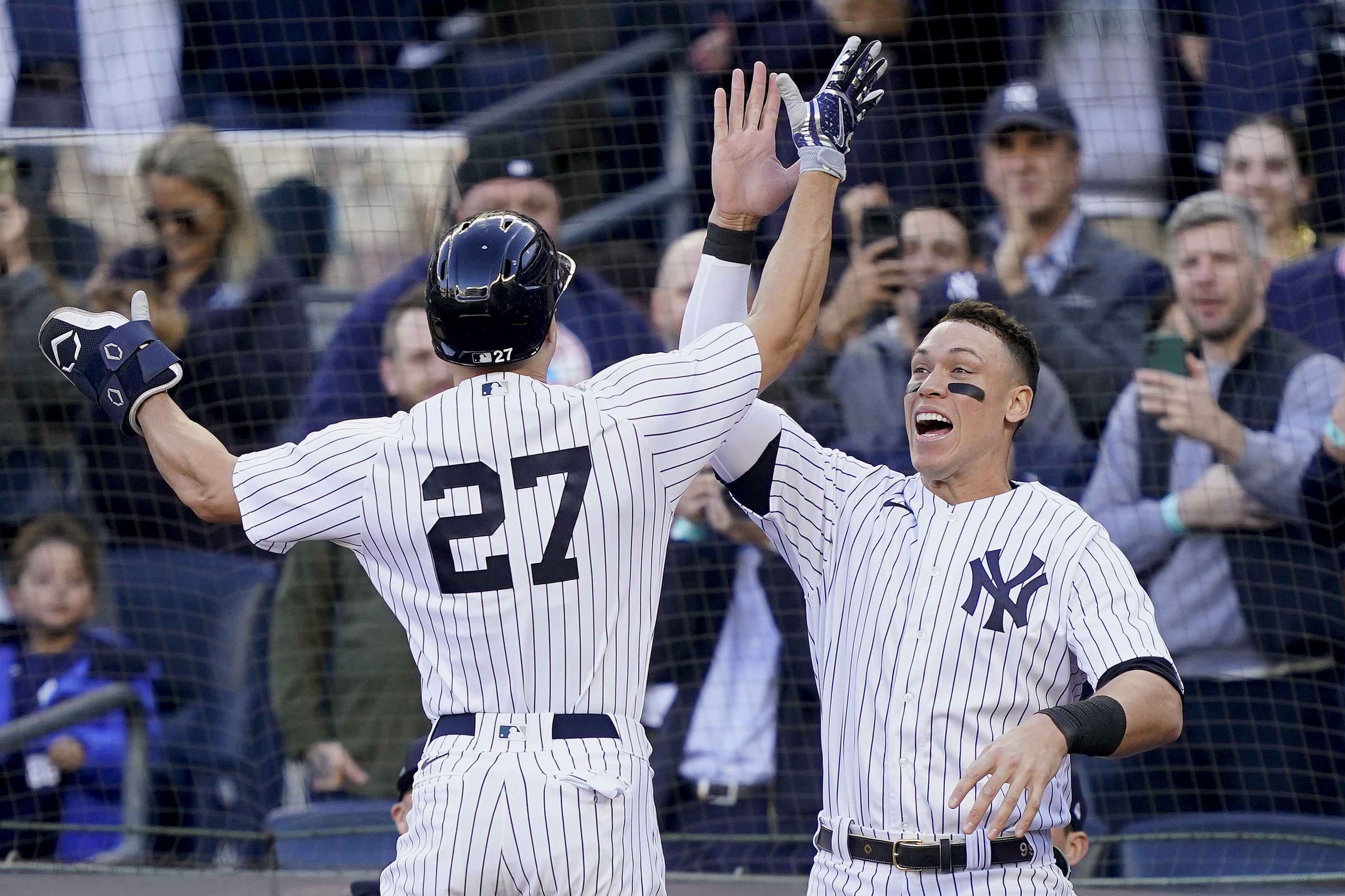 New York Yankees Giancarlo Stanton (27) celebrates with Aaron Judge after hitting a three-run home run against the Cleveland Guardians during the first inning of Game 5 of an American League Division baseball series, Tuesday, Oct. 18, 2022, in New York.