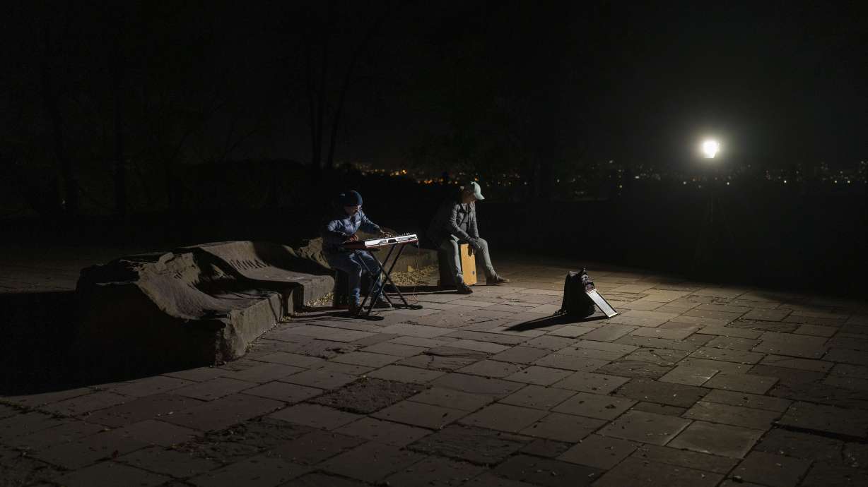 Street musicians play their instruments in a square without electric lights in Kyiv, Ukraine, Tuesday.