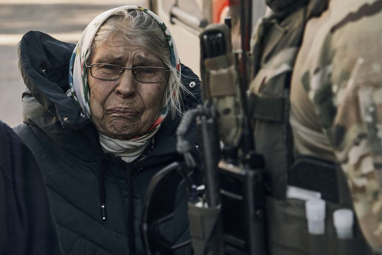 An elderly woman reacts as she leaves her house located in a combat zone in the village of Zarechne, Donetsk region, Monday.