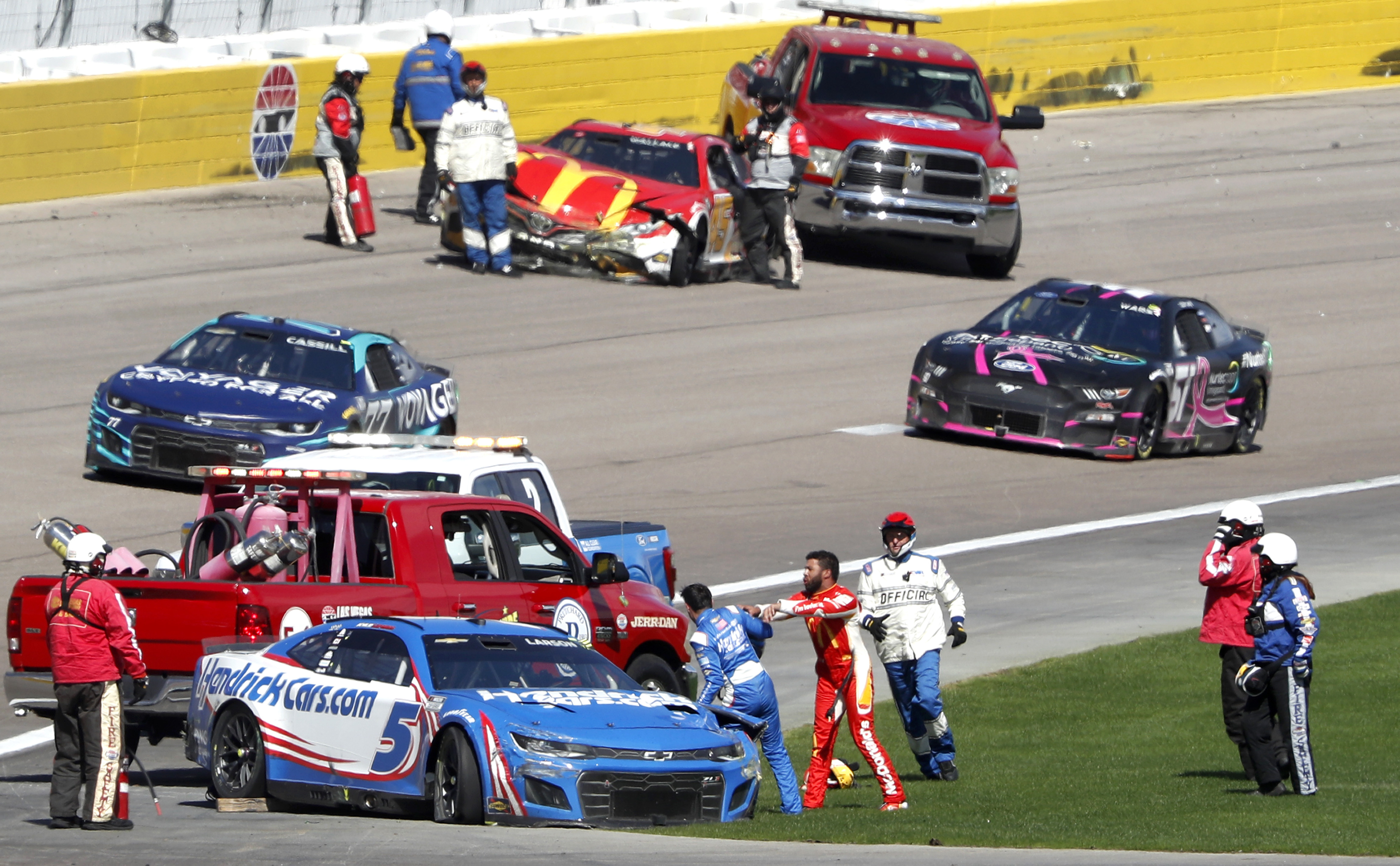 Bubba Wallace, center right, shoves Kyle Larson (5) after they crashed during a NASCAR Cup Series auto race at Las Vegas Motor Speedway in Las Vegas, Sunday, Oct. 16, 2022. 
