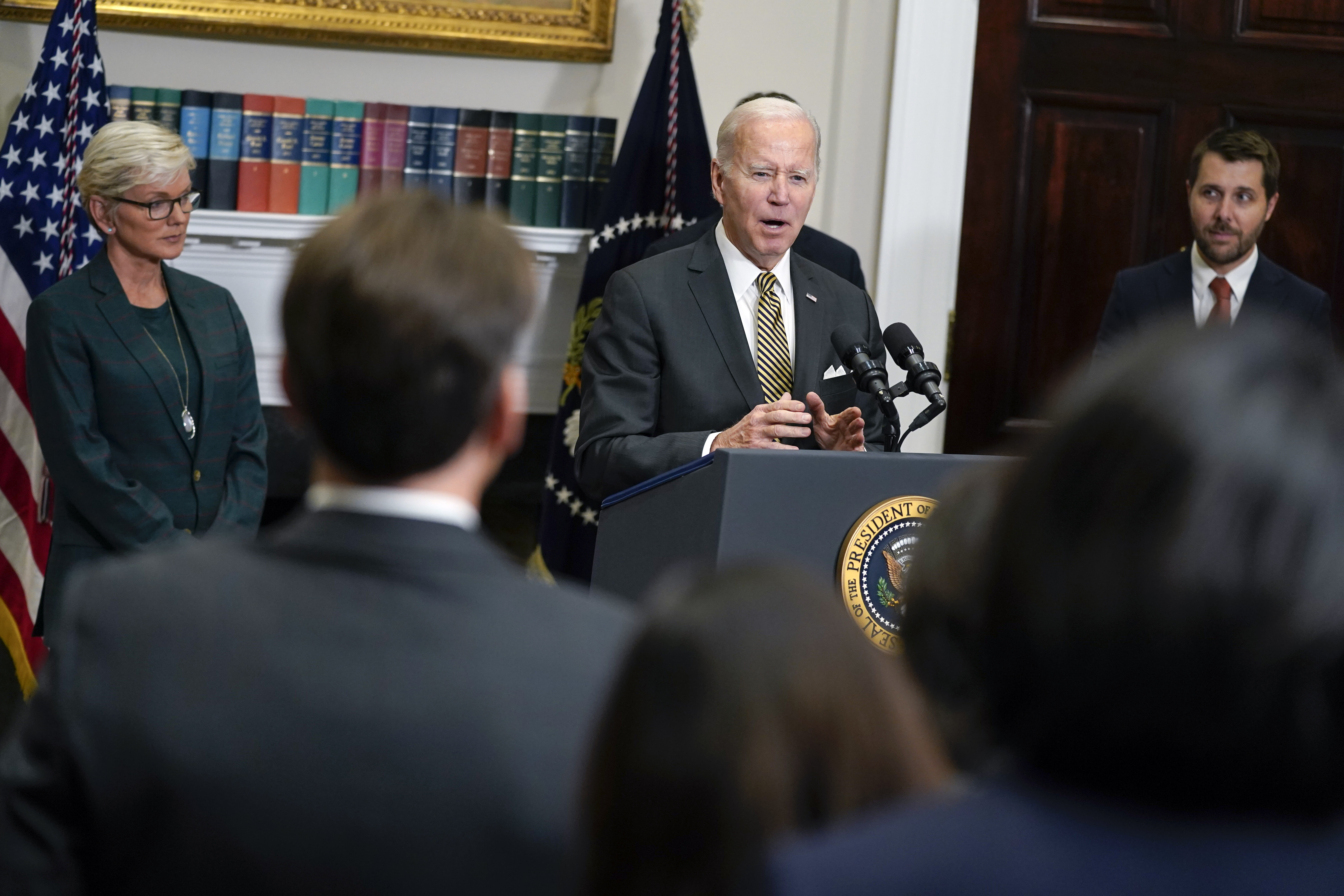 Energy Secretary Jennifer Granholm, left, and National Economic Council director Brian Deese, right, listen as President Joe Biden speaks during an event in the Roosevelt Room of the White House, Wednesday, in Washington.