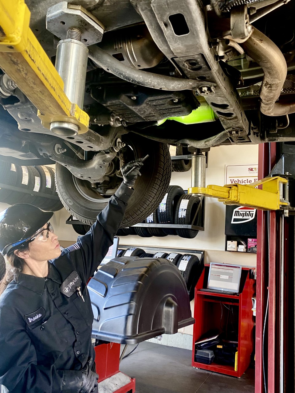 An employee at Jiffy Lube on Thursday engraves the VIN number on the catalytic converter and puts a heat resistant fluorescent stripe over it. Police hope the procedures will deter thieves from stealing catalytic converters.