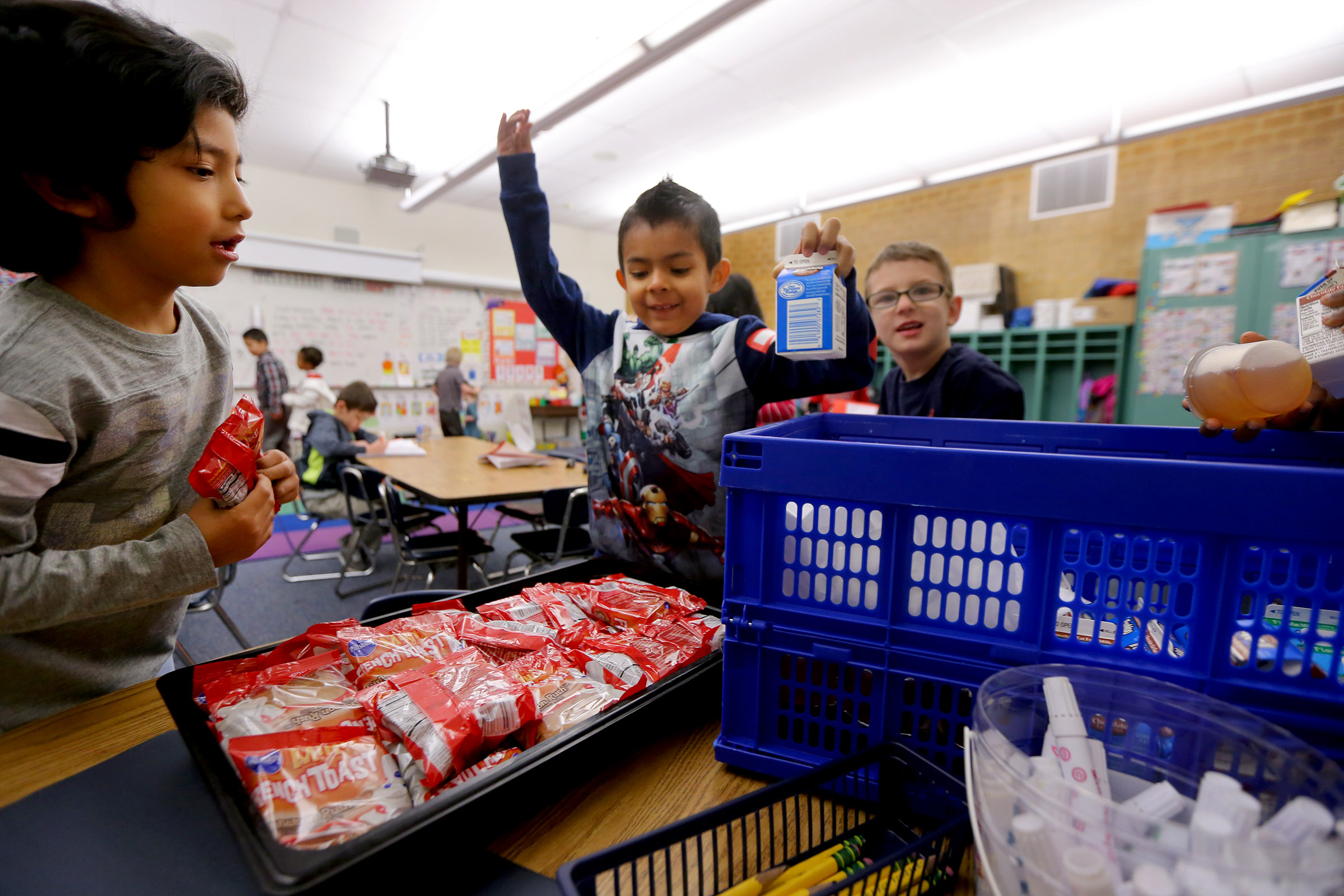 Diego Joaquin Florez and Fernando Mendiola-Gacia take their food as students at Granite District's James E. Moss Elementary School eat their breakfast in their classroom after school has started for the day on March 18, 2016. Almost 1 in 5, or 19%, of Utah public school students are Hispanic.