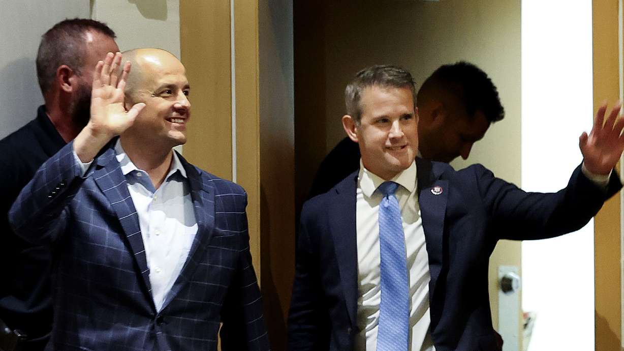 Evan McMullin, an independent candidate for U.S. Senate, left, and Rep. Adam Kinzinger, R-Ill., a member of U.S. House Jan. 6 Committee, acknowledge the audience’s applause before a forum on democracy at the Salt Lake City Public Library on Thursday.