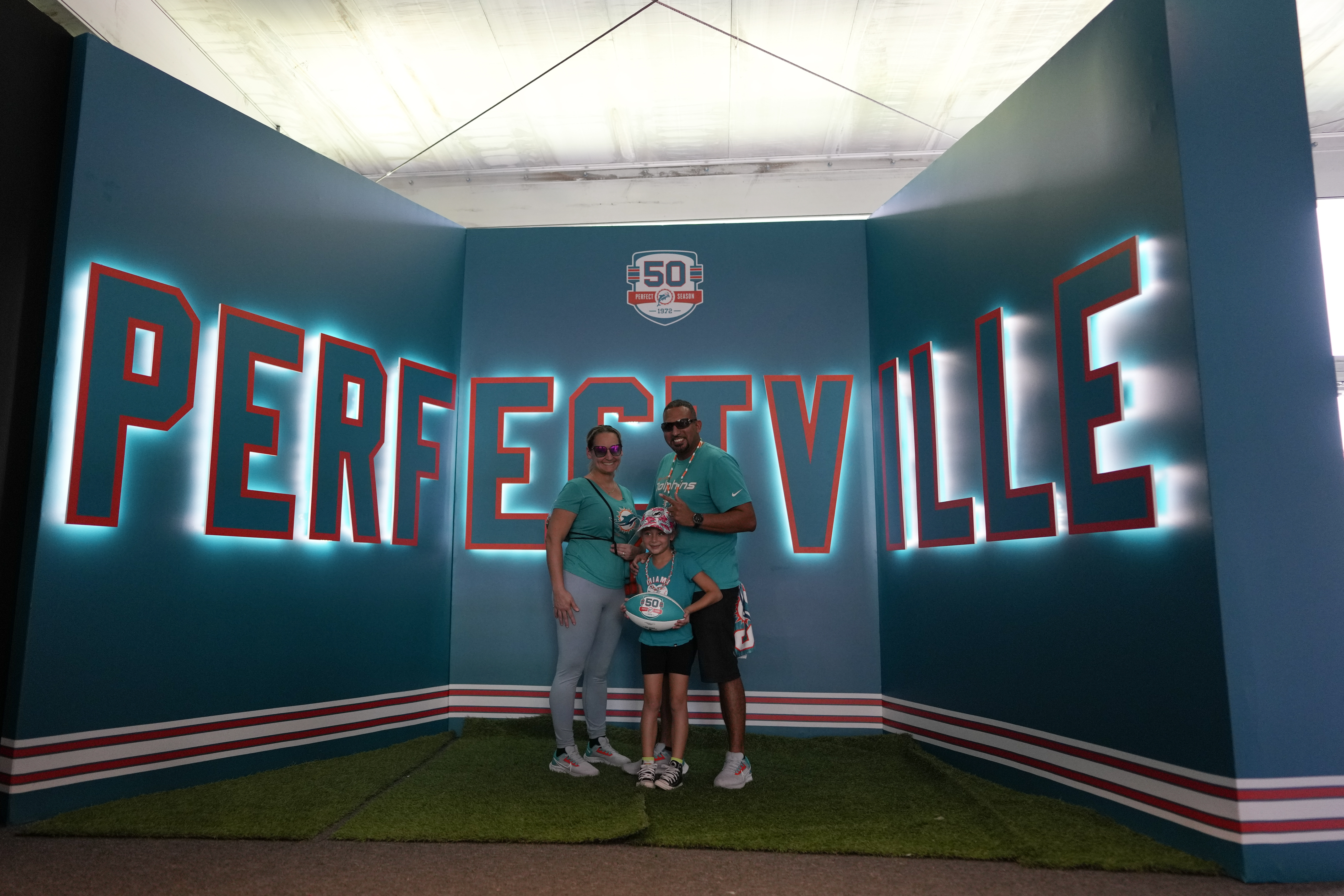 Miami Dolphins fans pose for a picture inside the Perfect Season Museum on the grounds of Hard Rock Stadium, in Miami Gardens, Fla., Sunday, Oct. 16, 2022. 