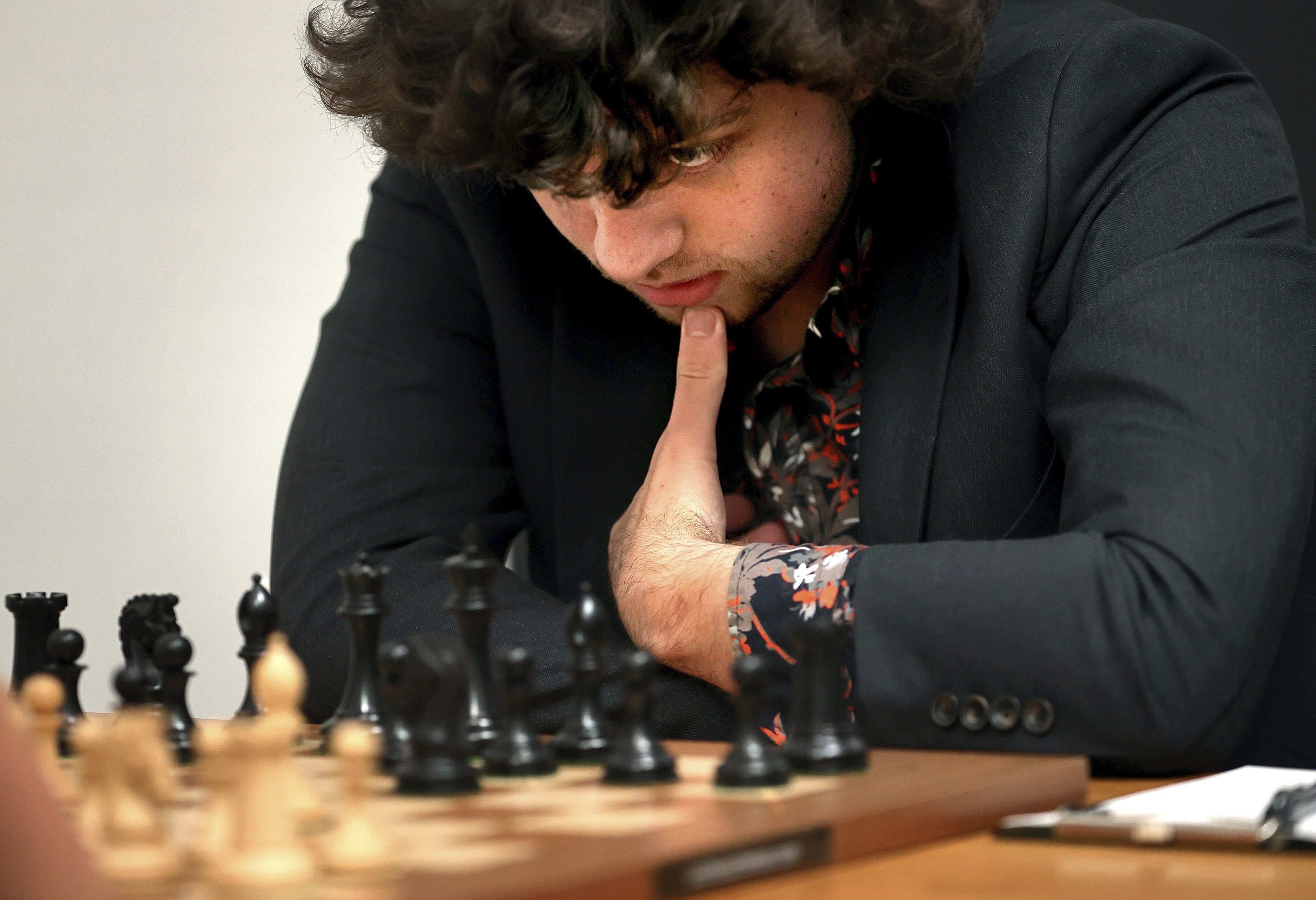 FILE - Chess Grandmaster Hans Niemann, 19, studies the board during a match against Grandmaster Christopher Yoo, 15, at the U.S. Chess Championship in St. Louis on Wednesday, Oct. 5, 2022. The U.S. Chess Championships opened play at the St. Louis Chess Club this week. Players, including 19-year-old Niemann, were greeted by a bevy of beefed-up security measures. They were scanned by security wands designed to detect not just metal but silicon, commonly used in electronics.