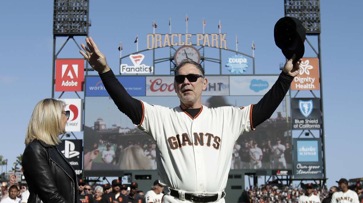 FILE - San Francisco Giants manager Bruce Bochy gestures toward fans next to his wife Kim during a ceremony honoring Bochy after a baseball game between the Giants and the Los Angeles Dodgers in San Francisco, Sunday, Sept. 29, 2019. The Texas Rangers have hired Bruce Bochy as their new manager, bringing the three-time World Series champion out of retirement to take over a team that has had six consecutive losing seasons. Texas made the surprise announcement Friday, Oct. 21, 2022, just more than two weeks after its season ended.