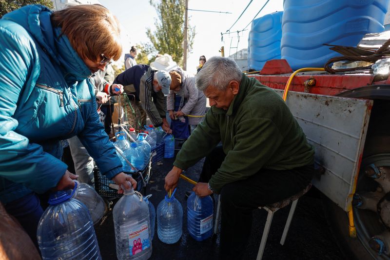 Local people fill up bottles with fresh drinking water, as the main supply pipeline for drinking water for the city was damaged in Kherson region at the beginning of Russia's attack on Ukraine, in Mykolaiv, Ukraine, Oct. 16.