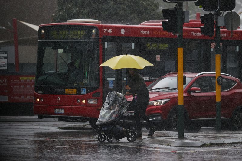 A pedestrian pushing a baby pram crosses a flooding intersection as heavy rains affect Sydney, Australia, Oct. 6.