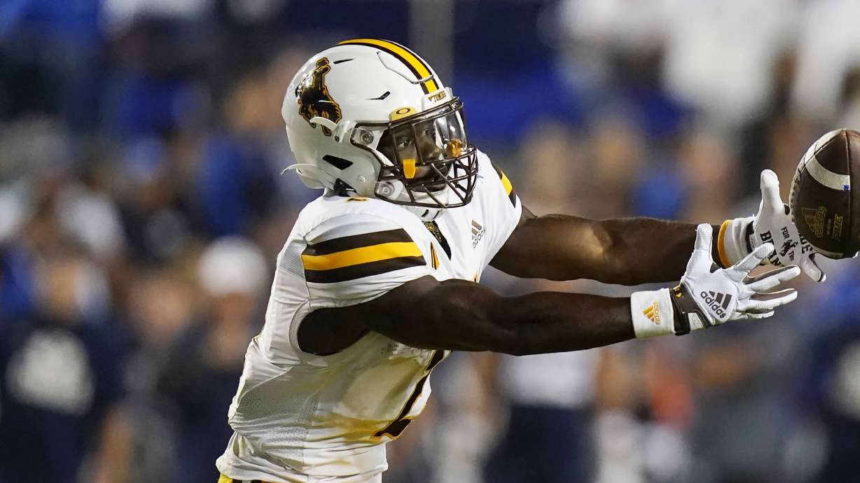 Wyoming running back Titus Swen (2) reaches for the ball during the first half of an NCAA college football game against BYU Saturday, Sept. 24, 2022, in Provo, Utah.