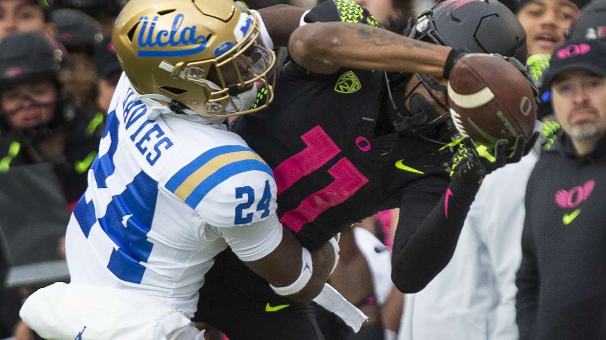 Oregon's Troy Franklin, right, pulls down a pass against UCLA's Jaylin Davies during the first half in an NCAA college football game Saturday, Oct. 22, 2022, in Eugene, Ore.