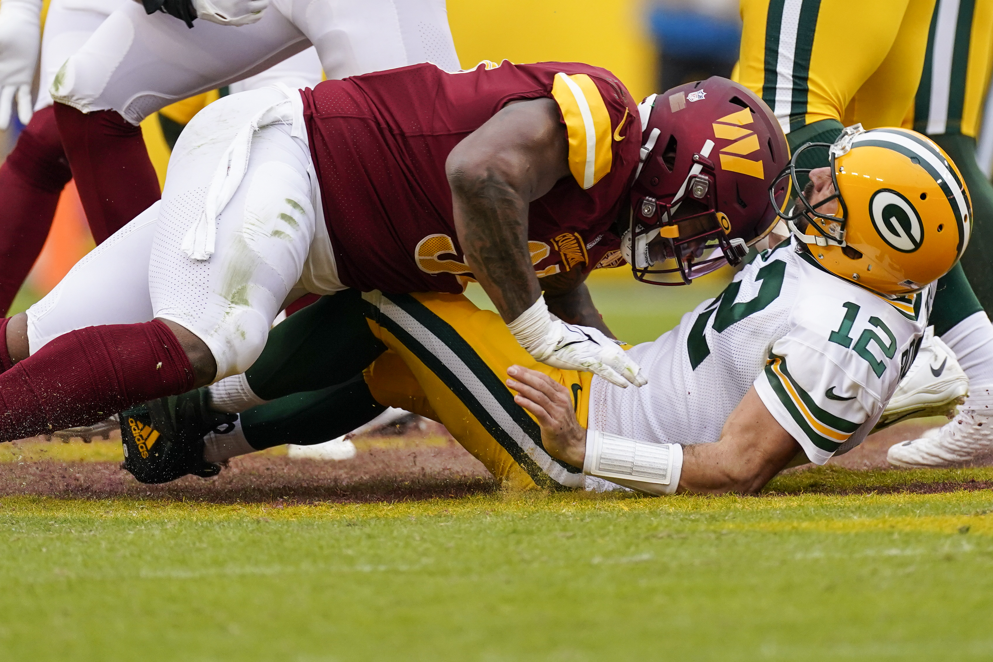 Washington Commanders defensive tackle Daron Payne, left, hits Green Bay Packers quarterback Aaron Rodgers (12) during the second half of an NFL football game Sunday, Oct. 23, 2022, in Landover, Md. Payne was given a roughing the passer penalty. 