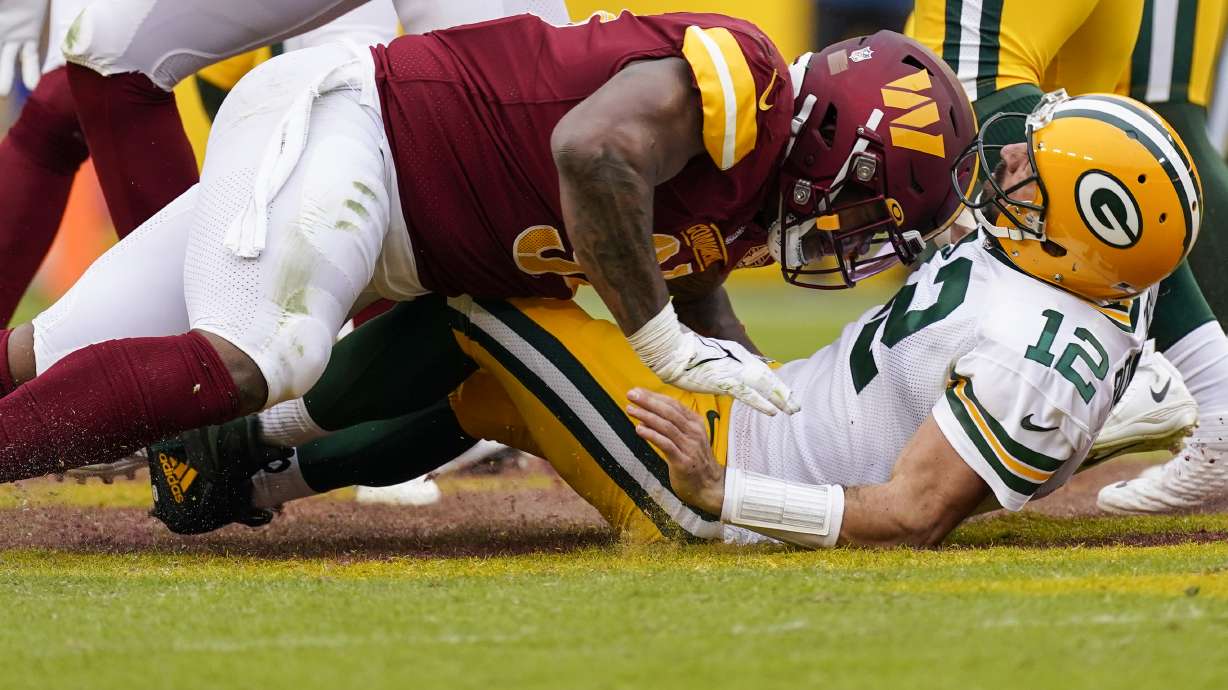 Washington Commanders defensive tackle Daron Payne, left, hits Green Bay Packers quarterback Aaron Rodgers (12) during the second half of an NFL football game Sunday, Oct. 23, 2022, in Landover, Md. Payne was given a roughing the passer penalty.
