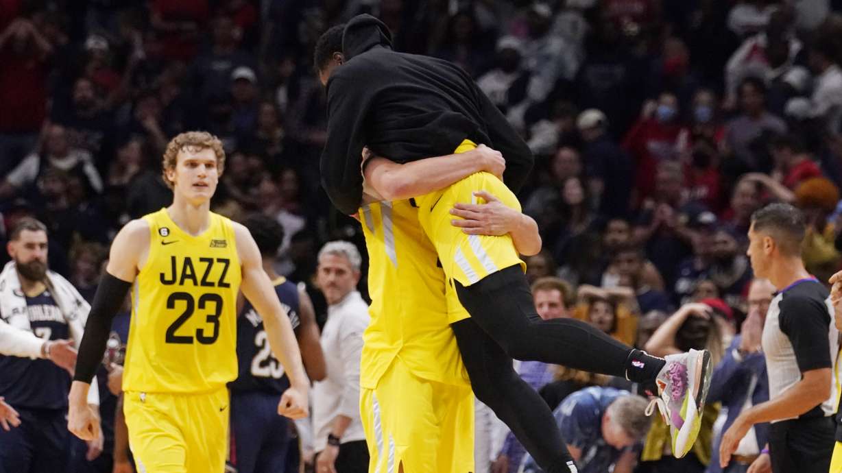 Utah Jazz forward Kelly Olynyk, center below, is hugged by teammates after defeating the New Orleans Pelicans in overtime during an NBA basketball game in New Orleans, Sunday, Oct. 23, 2022. The Jazz won122-121.
