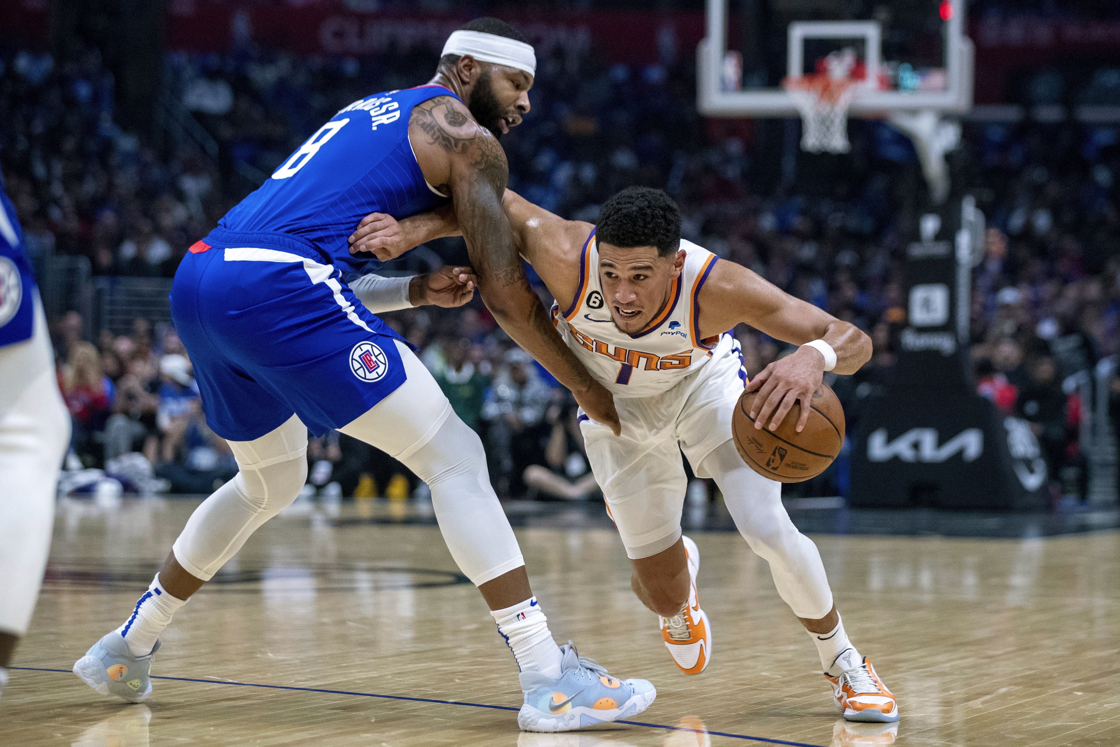 Phoenix Suns guard Devin Booker, right, drives past Los Angeles Clippers forward Marcus Morris Sr., during the first half of an NBA basketball game, Sunday, Oct. 23, 2022 in Los Angeles. 