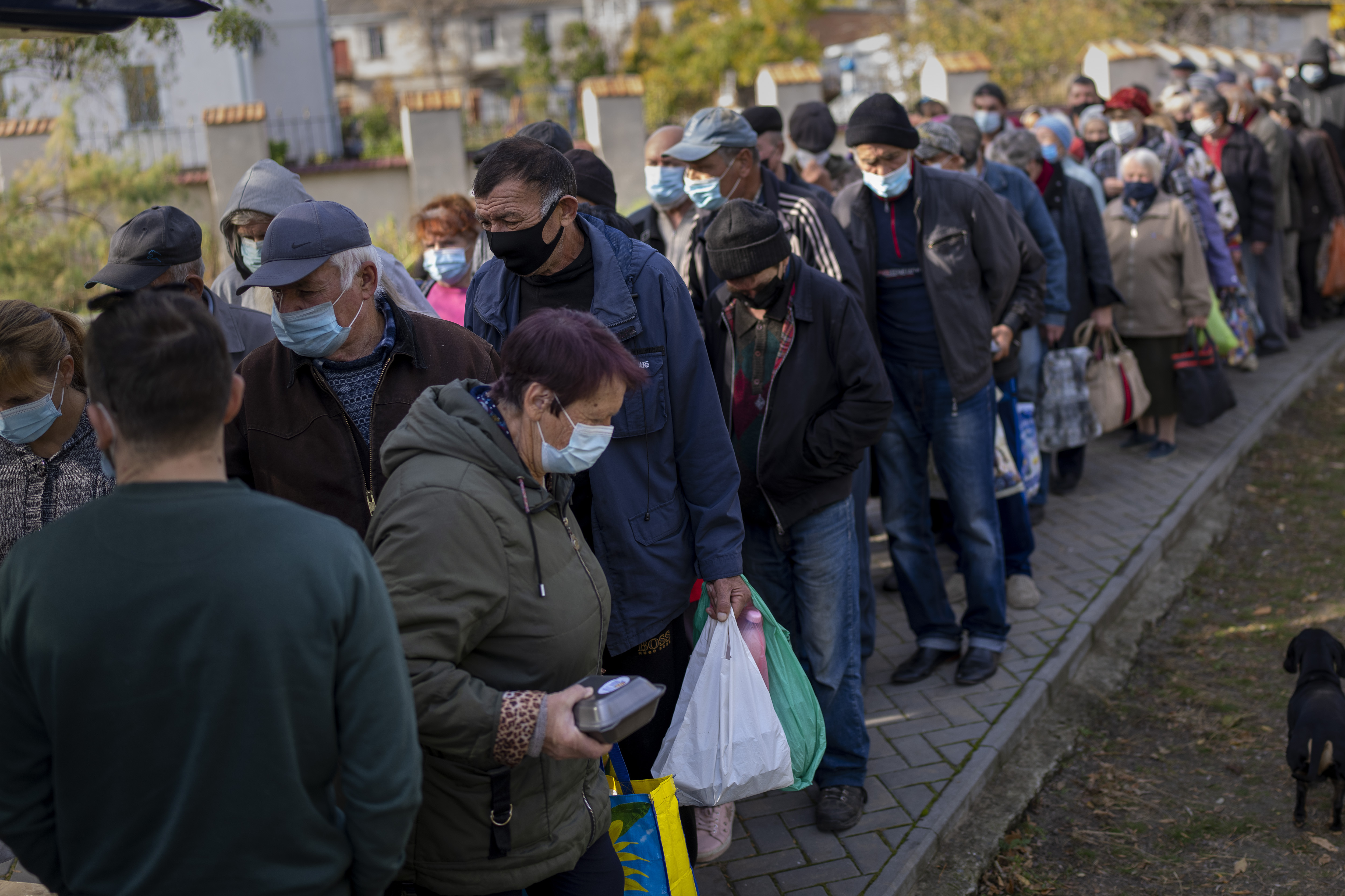 People queue up to wait for ration food from World Central Kitchen organization in the center of Mykolaiv, Monday. Ukrainian authorities on Monday tried to dampen public fears over Russia's use of Iranian-built drones on its neighbor by claiming increasing success in shooting down the small aircraft.