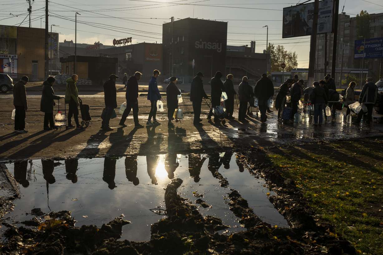 People queuing up hold plastic bottles to refill drinking water from a tank in the center of Mykolaiv, Monday.