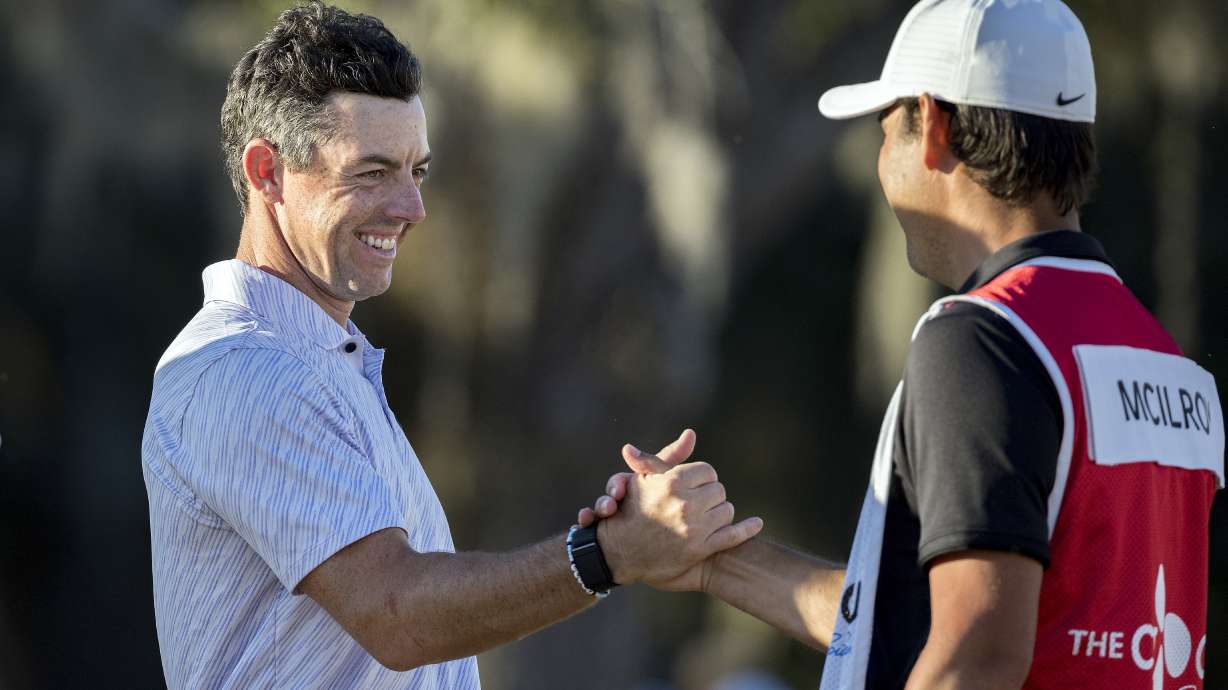 Rory McIlroy, left, of Northern Ireland, left, celebrates with his caddie after the final round of the CJ Cup golf tournament Sunday, Oct. 23, 2022, in Ridgeland, S.C.