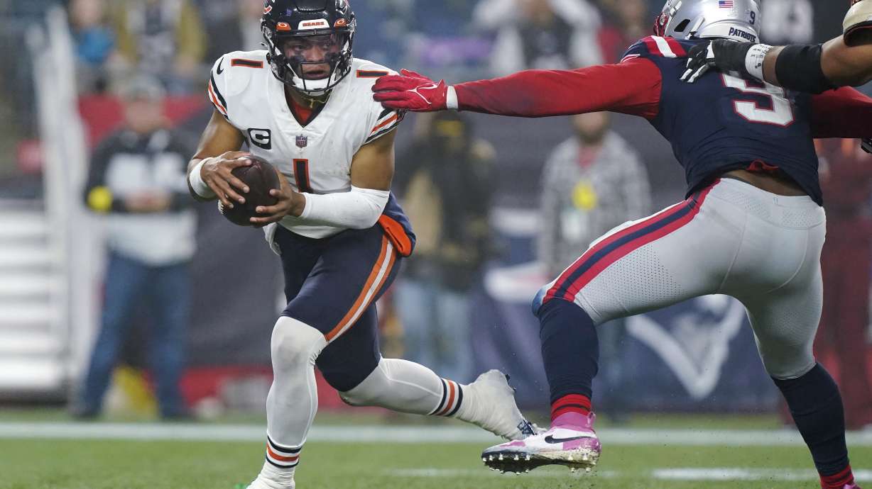 Chicago Bears quarterback Justin Fields (1) eludes New England Patriots linebacker Matthew Judon (9) during the second half of an NFL football game, Monday, Oct. 24, 2022, in Foxborough, Mass.