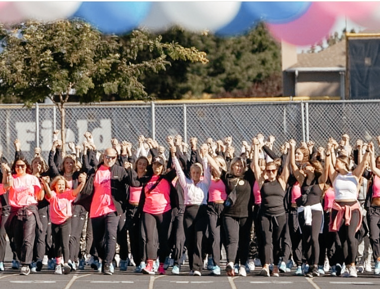 On the last lap of the Astra Walk walk-a-thon participants hold hands and raise them as they finish the lap.