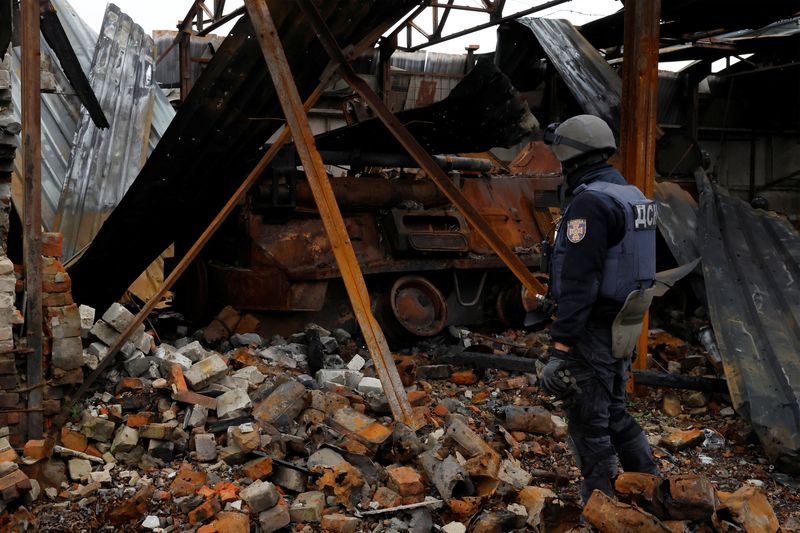 Firefighter Alexander from the de-mining squad of the Ukrainian emergency services enters a burned out tank to search, as they clear an area from shells and other explosive devices, as Russia's invasion of Ukraine continues, close to the Russian border in Kazacha Lopan, Ukraine, Oct. 25.