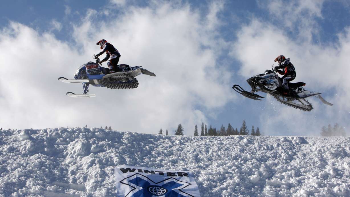 FILE - In this Jan. 31, 2010, file photo, Colby Crapo, left, leads Carl Schubitzke over a jump during a heat to determine placement in the snowmobile snocross final at the Winter X Games at Buttermilk Mountain outside Aspen, Colo. ESPN sold its majority stake in the X and Winter X Games on Wednesday, Oct. 26, 2022 marking the end of a nearly three-decade chapter during which the network helped propel snowboarding, skateboarding and other action sports out of the fringe and into the mainstream.